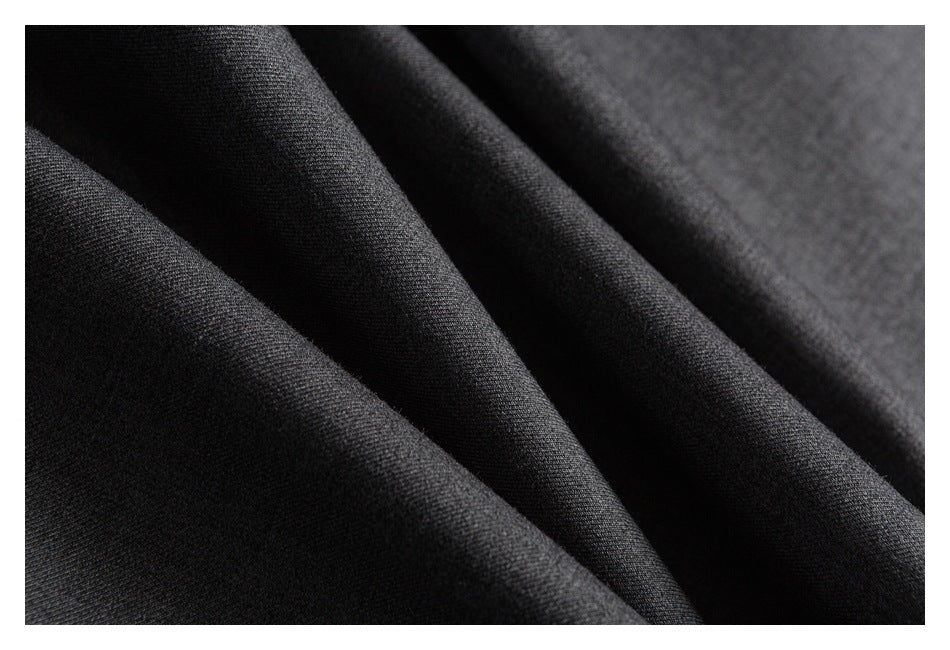 Macro view of charcoal gray fabric draped into soft folds.