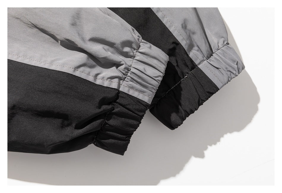 Close-up of gray and black color-block garment with gathered elastic cuffs.