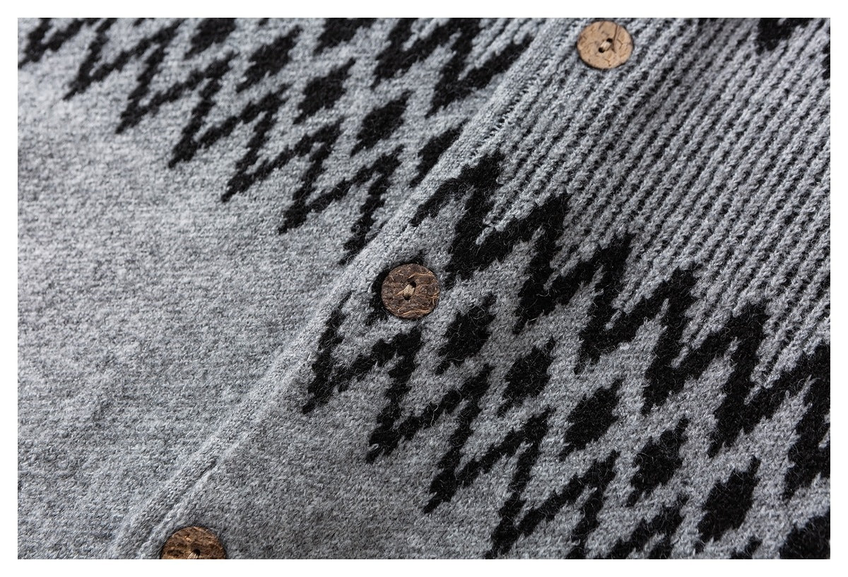 Close-up of a gray sweater's black zigzag knit pattern and brown buttons.