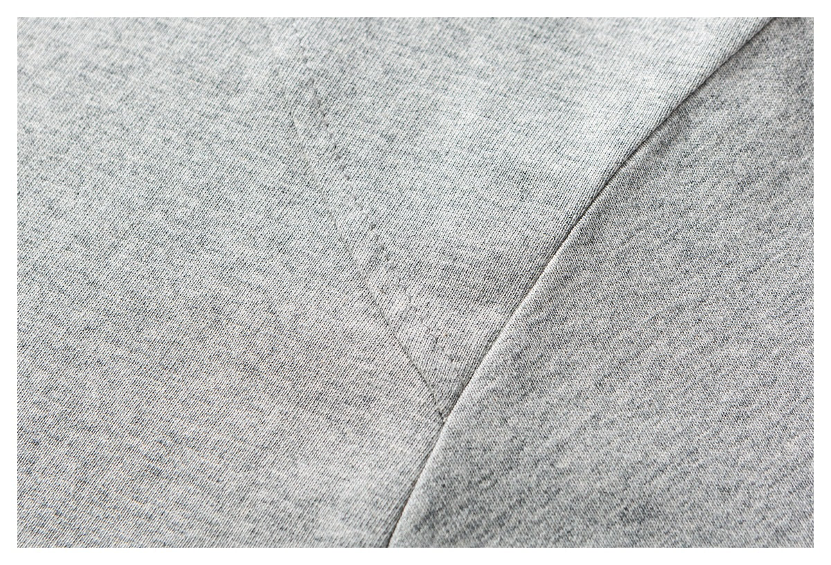 Close-up of heather gray knit fabric with a curved stitched seam.