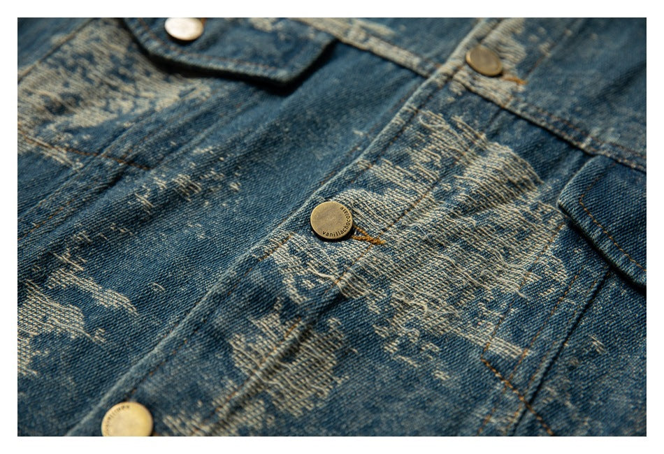 Close-up of distressed blue denim with a button-front placket, pockets, and metal buttons.