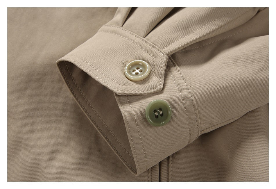 Close-up of a beige jacket sleeve cuff with two contrasting buttons.
