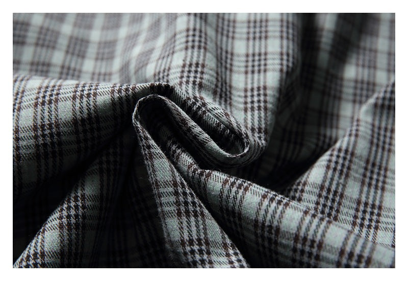Close-up of the gray and dark plaid fabric draped into folds.