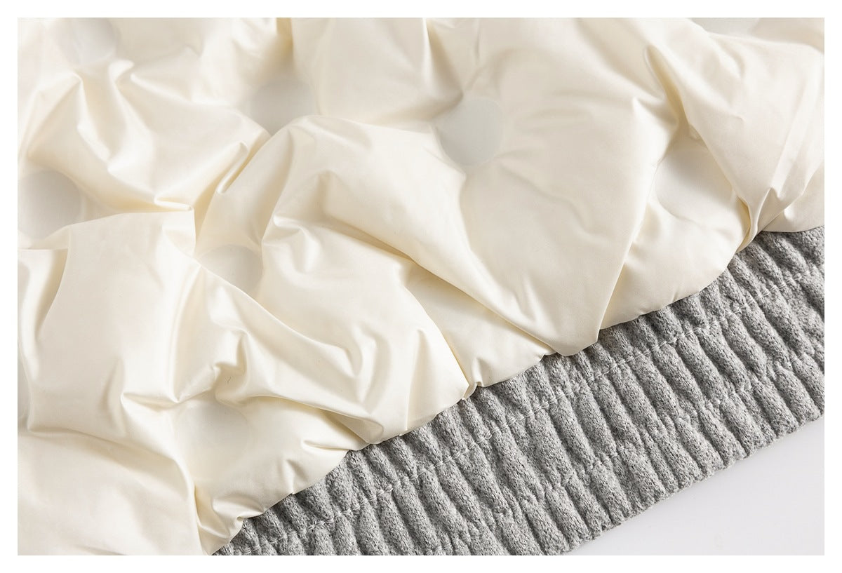 Close-up of cream-colored lining beside a gray ribbed garment hem.