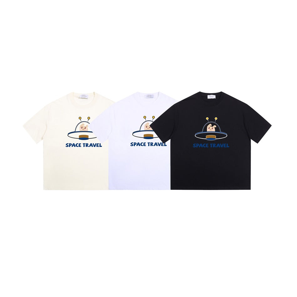 Three crew-neck T-shirts in ivory, white, and black, each with a cartoon UFO and “SPACE TRAVEL” print.