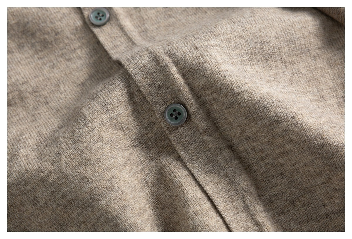 Close-up of a taupe knit cardigan's button placket with two dark buttons.