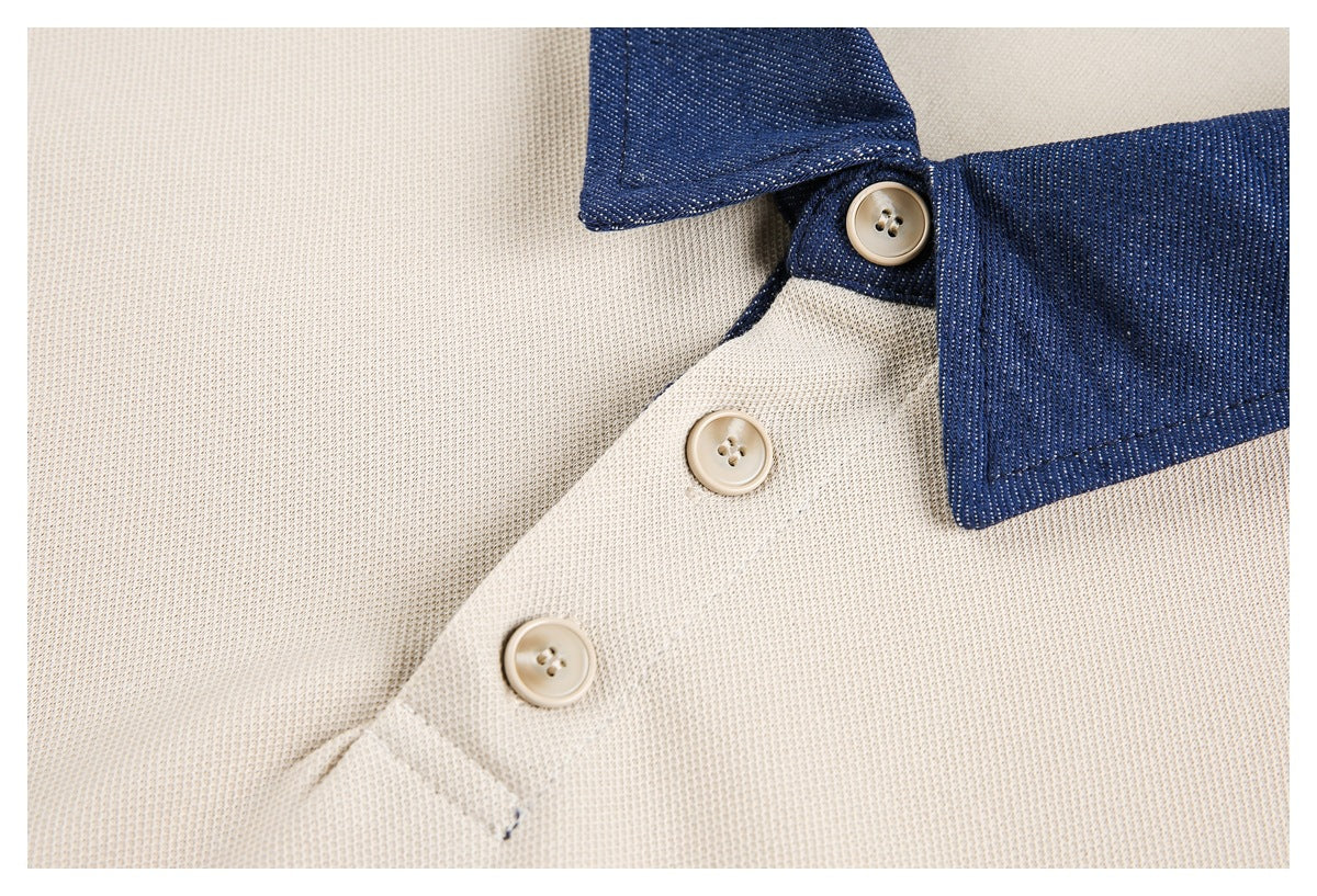 Close-up of a cream shirt placket with beige buttons and a dark navy collar.