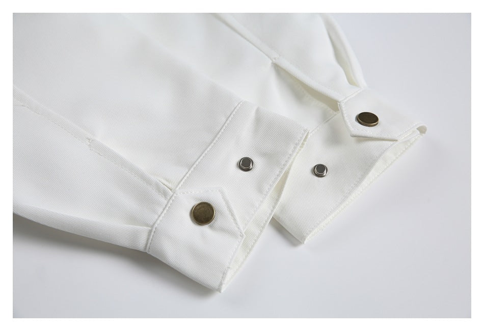 Close-up of white garment cuffs with snap closures and bronze-tone buttons.