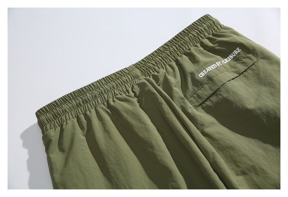 Olive-green shorts waistband and rear pocket with white embroidered lettering.