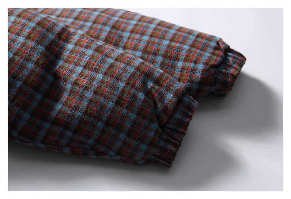 Close-up of a folded sleeve and plaid cuff in blue, red, and brown checks.