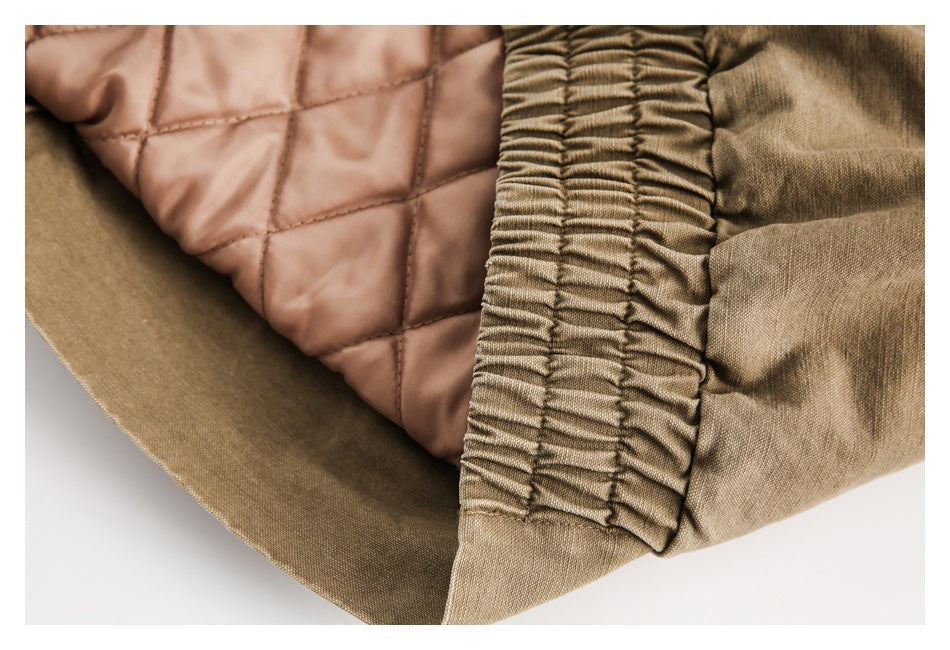 Close-up of a tan garment’s gathered elastic edge beside pale brown diamond-quilted lining.