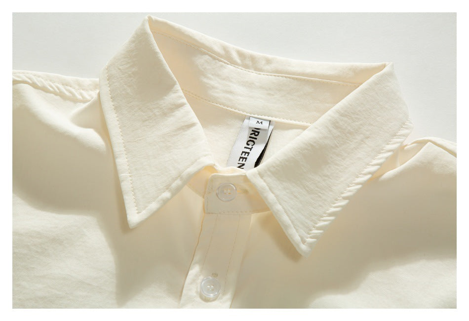 Close-up of the ivory shirt's oversized pointed collar, placket, and top buttons.