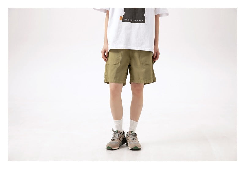 Front view of a model wearing olive-green shorts with large patch pockets.