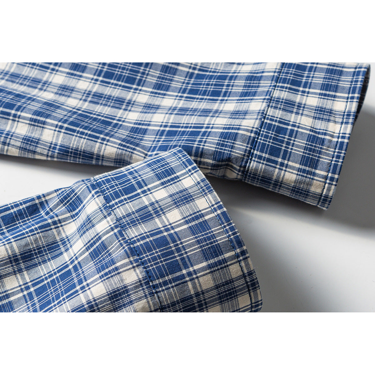 Close-up of the blue and white plaid shirt sleeve and cuff.