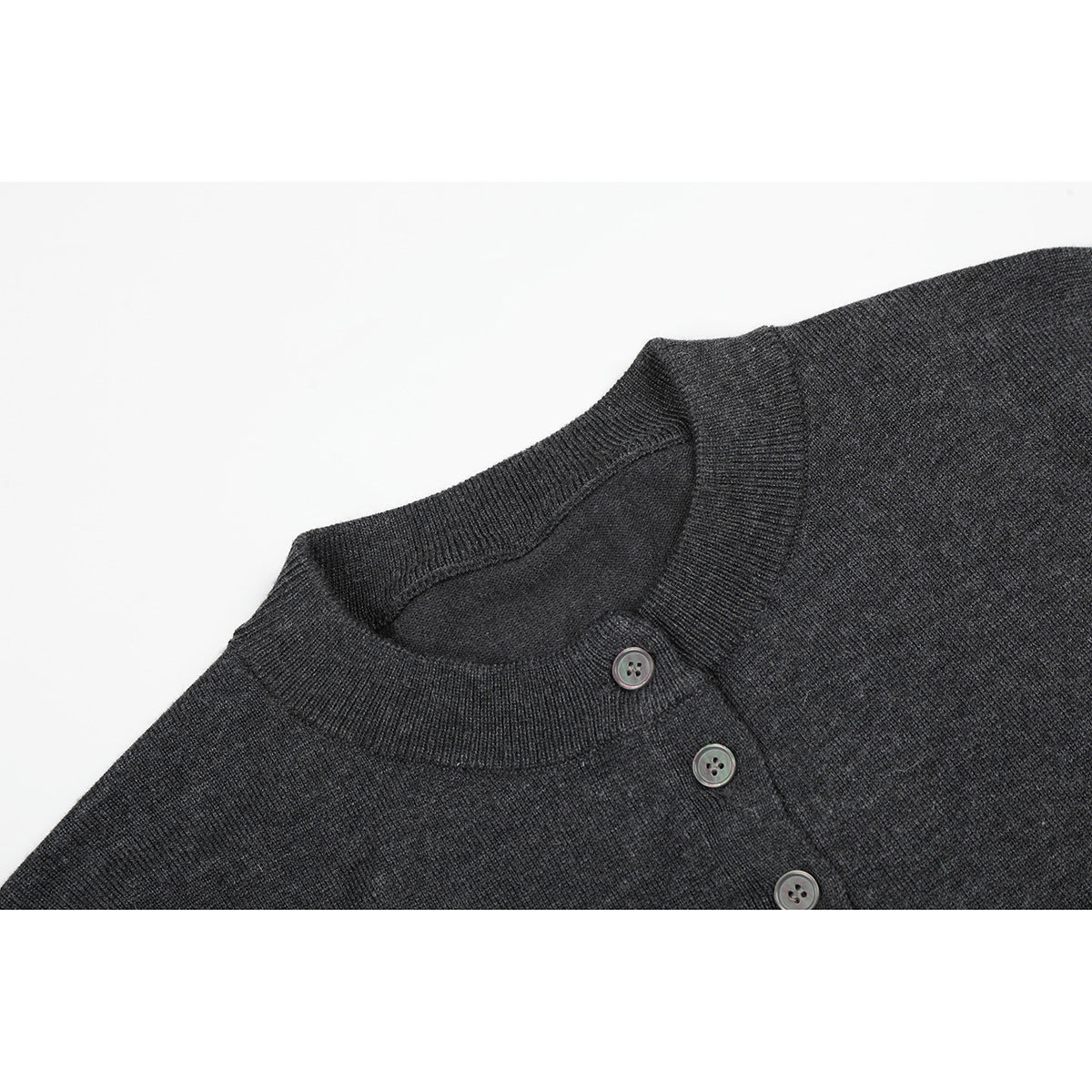 Close-up of a charcoal knit top's ribbed crew neck and short button placket.