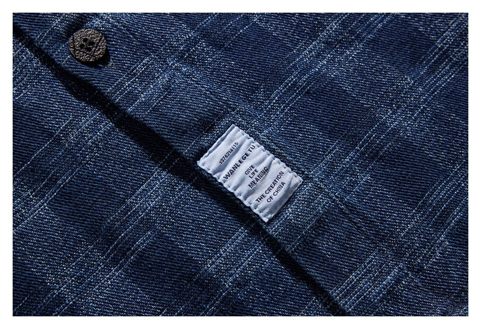 Close-up of a sewn-in garment label against dark blue plaid fabric.
