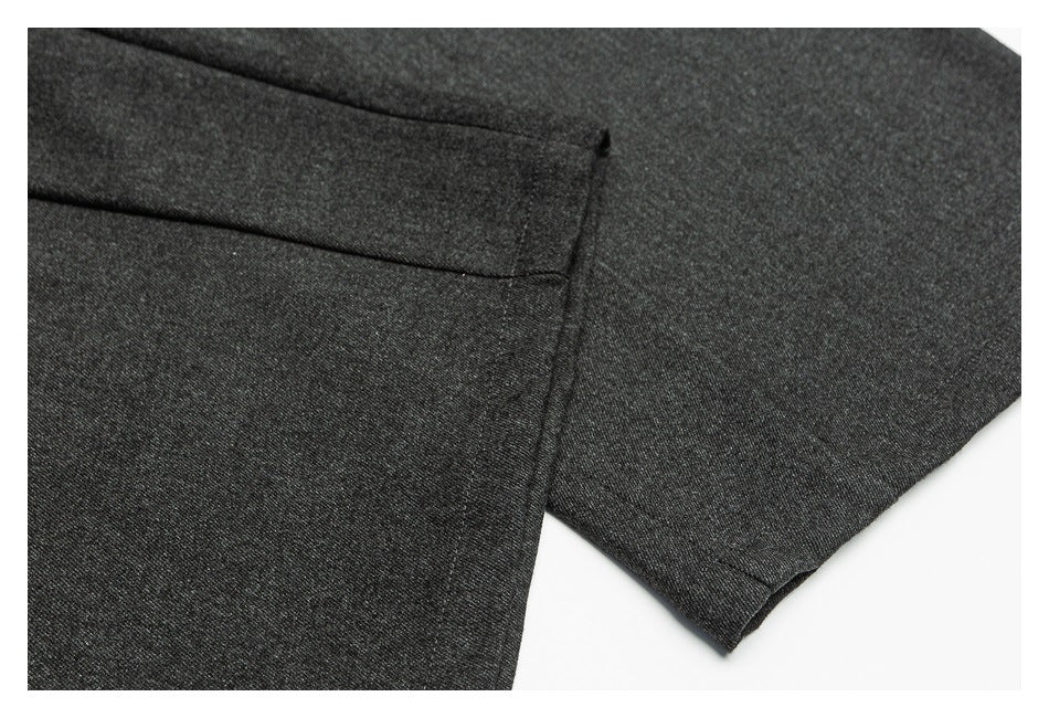 Close-up of charcoal trousers showing a folded hem and stitching.