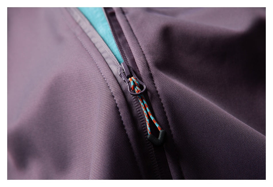 Close-up of a purple garment zipper with a multicolored cord pull and teal lining.