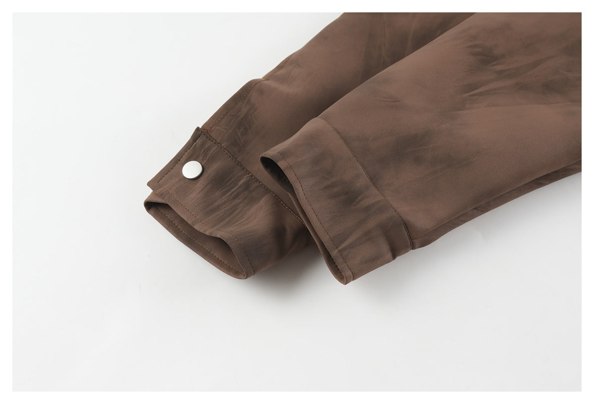 Close-up of the brown jacket sleeve and cuff, showing a snap fastener and folded cuff detail.