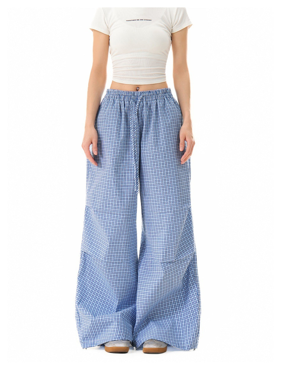 Model wearing blue plaid wide-leg drawstring pants with a white cropped tee, front view, cropped at the torso