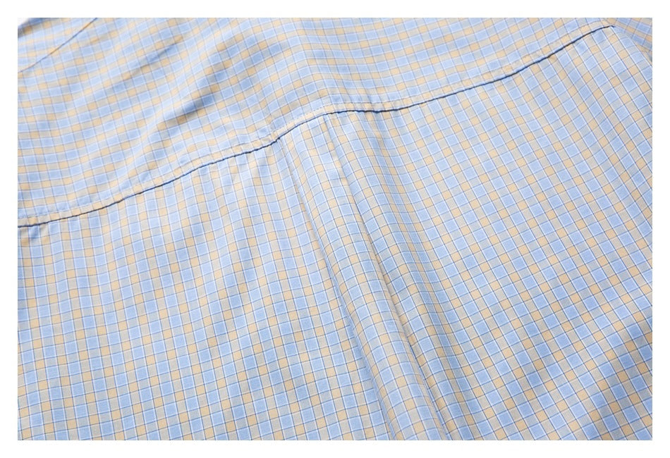 Close-up of the plaid shirt's back panel and curved seam.