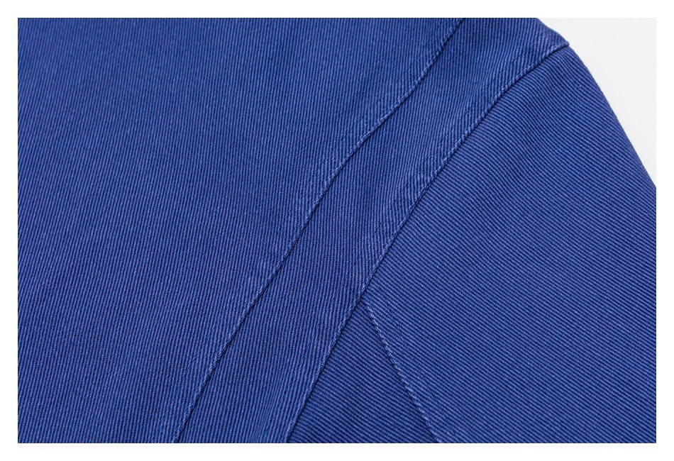 Close-up of intersecting seams on blue garment fabric.