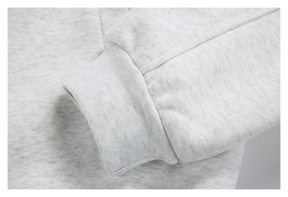 Close-up of a light gray marled sweatshirt sleeve and ribbed cuff.