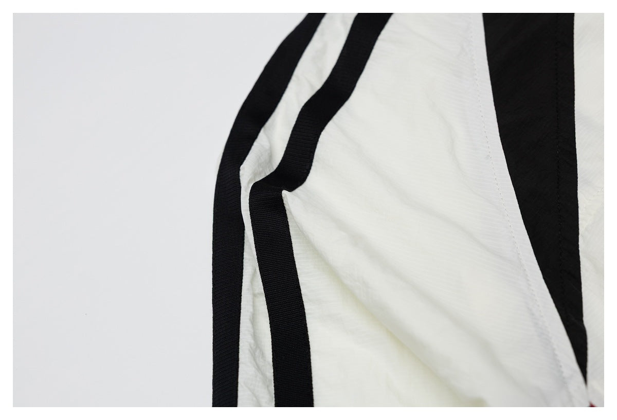 Close-up of broad black trim running along the white garment panels.