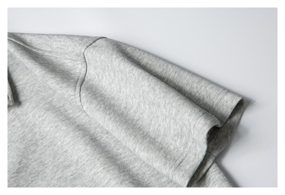 Close-up of a light gray heather knit sleeve and curved seam.