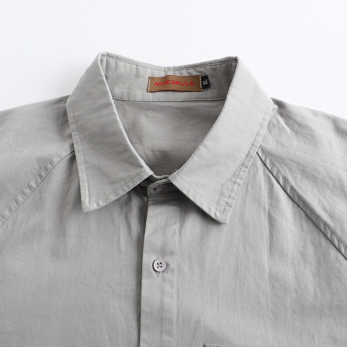 Close-up of a light gray shirt collar, button placket, and sewn-in neck label.