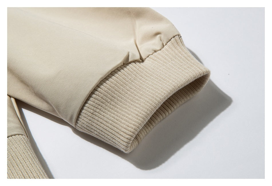 Close-up of a wide ribbed knit cuff on a light beige sleeve.