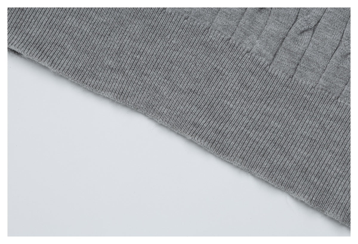Close-up of the gray top's wide ribbed hem and adjacent cable-knit panels.
