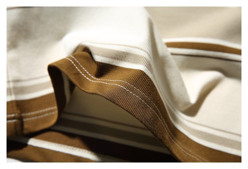 Close-up of the striped top's brown ribbed hem edge and parallel rows of stitching.