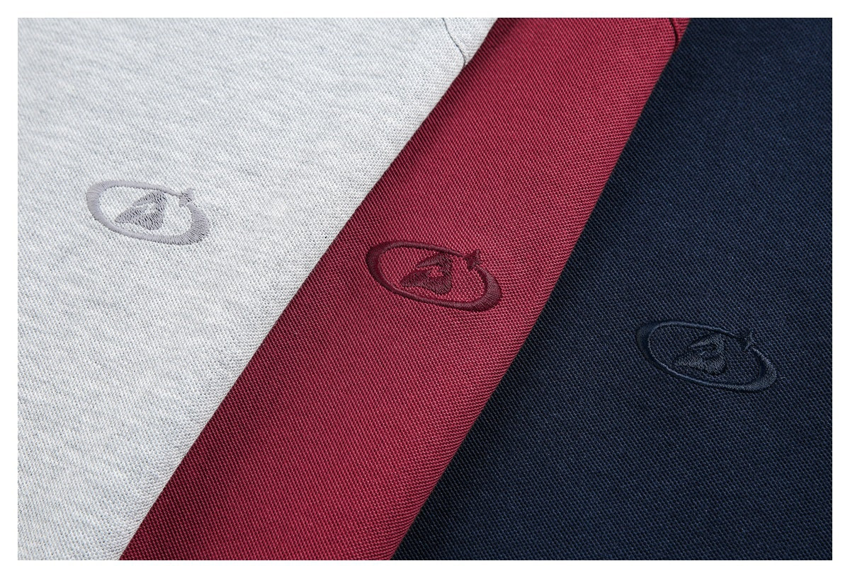 Close-up of three polo shirts in light gray, burgundy, and navy, each with a small embroidered emblem.
