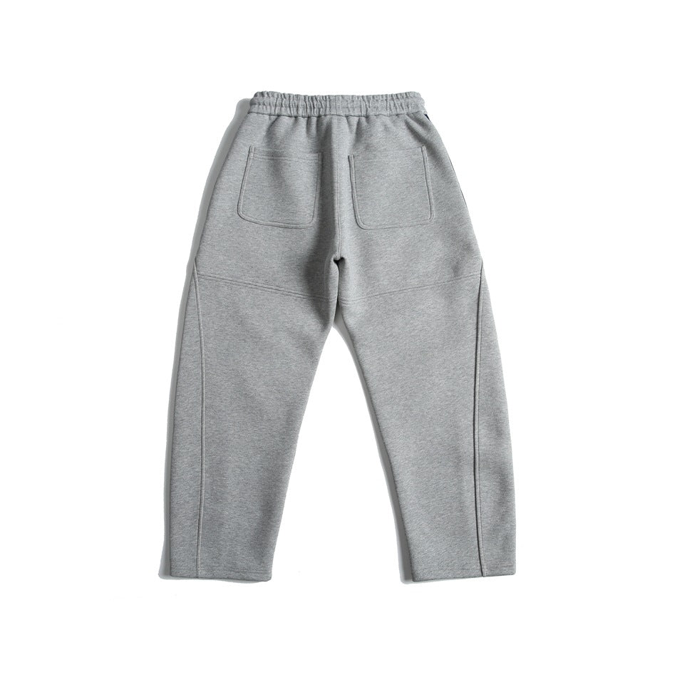 Back view of heather gray sweatpants with an elastic waistband, two patch pockets, and seam details.