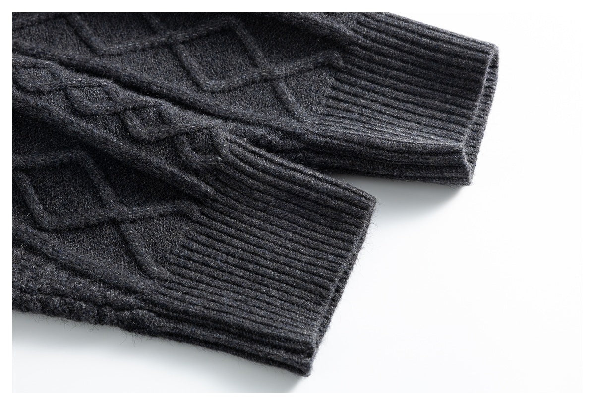 Close-up of the ribbed cuffs and cable-knit sleeves of a charcoal gray cardigan.