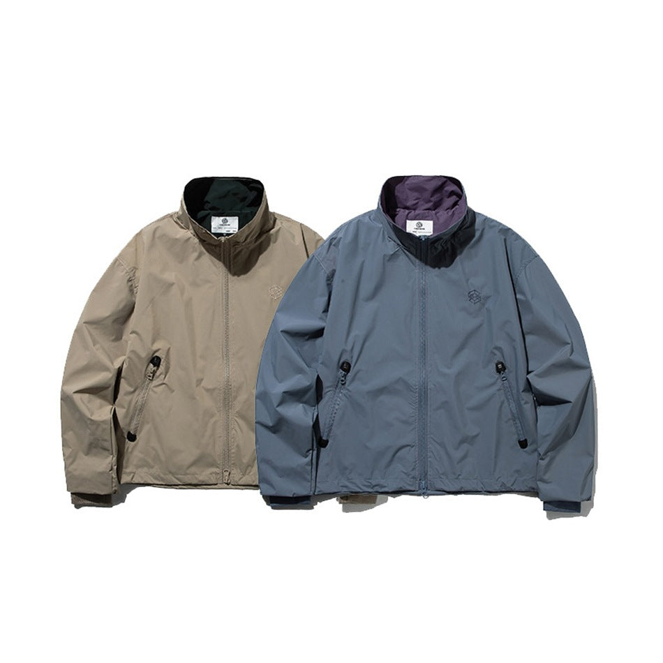 Two front-facing stand-collar jackets: one taupe and one slate blue, both with front zippers and side pockets.