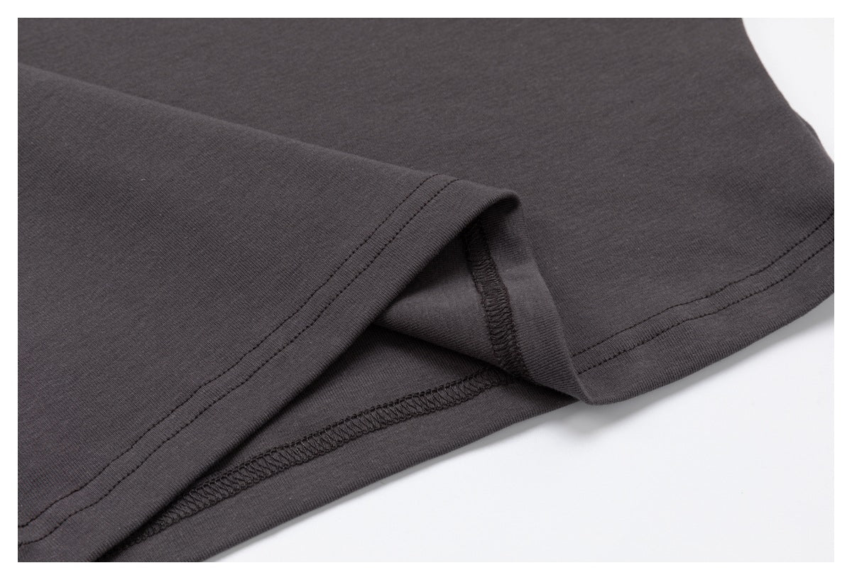 Close-up of the charcoal top's hem turned back to show the inside seam finishing.