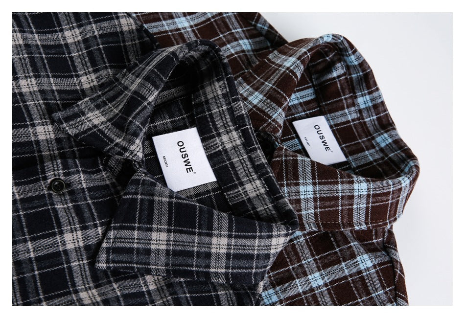 Close-up of black-gray and brown-blue plaid shirt collars with sewn-in white labels.