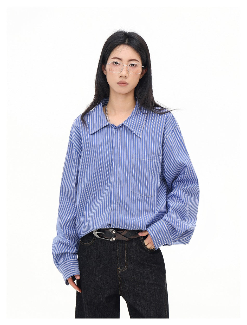 Model wearing a blue and white pinstriped long-sleeve shirt with a pointed collar and chest pocket.