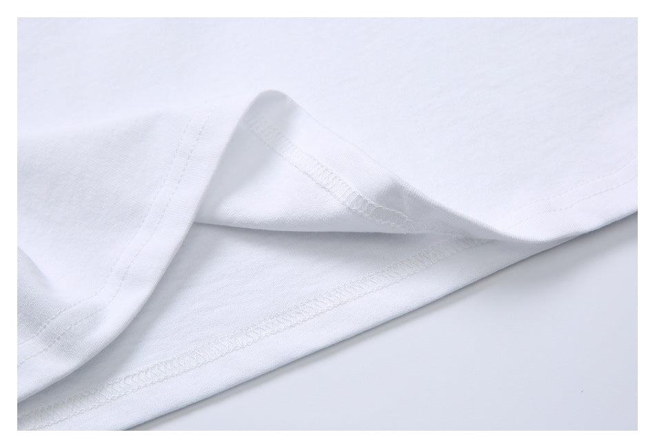 Close-up of a white shirt's folded hem and overlocked stitching.