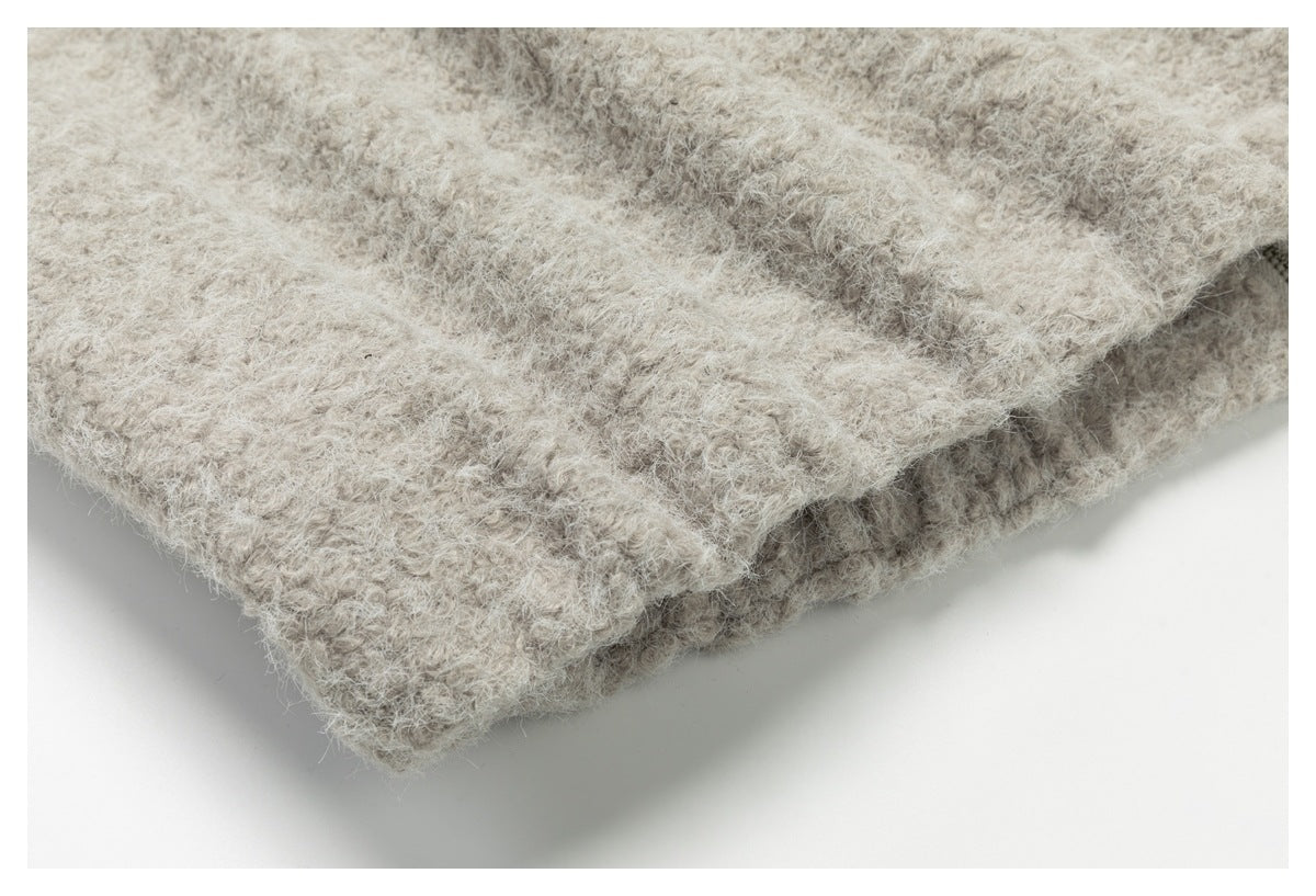 Close-up of a layered seam or edge on a light beige, fuzzy-textured garment.