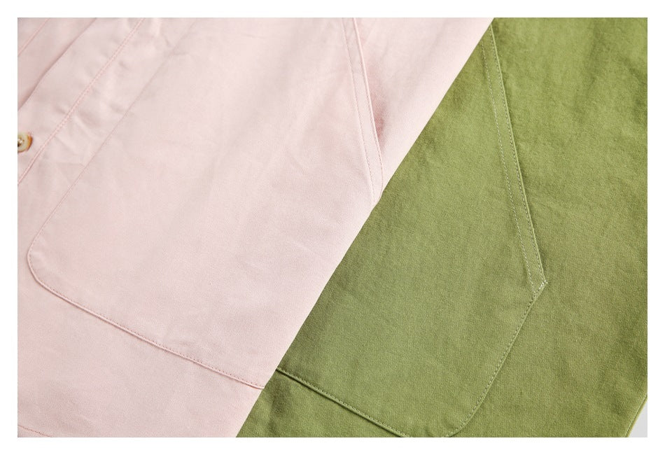 Close-up of large pocket details on pale pink and olive-green shirts.