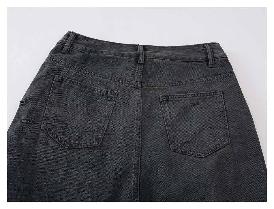 Rear close-up of charcoal-black jeans showing two back pockets, belt loops, and small distressed slits.