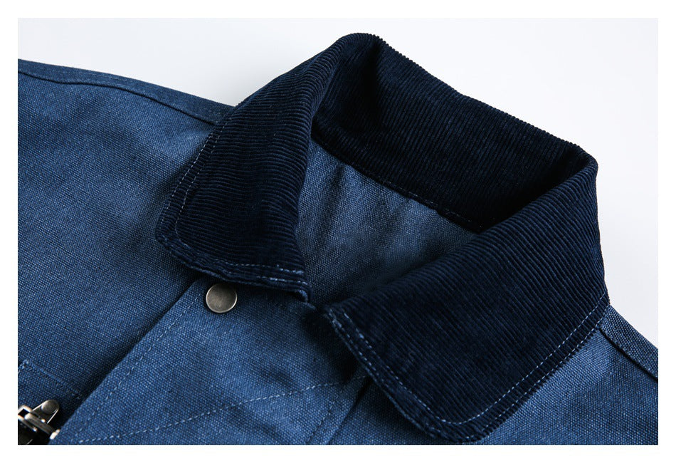 Close-up of a blue jacket's dark corduroy collar, stitching, and metal snap.