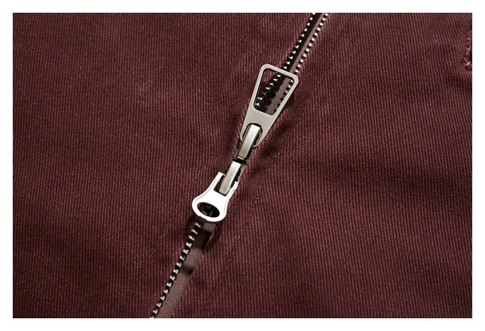 Close-up of a silver zipper on burgundy-brown ribbed garment fabric.