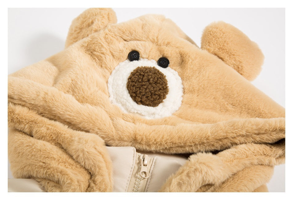 Close-up of the tan plush bear-face hood, with button eyes, a white muzzle and the jacket zipper below.