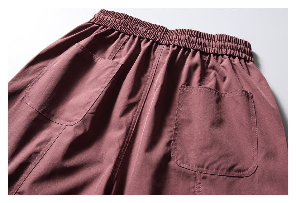 Rear view of dusty mauve trousers with an elastic waist and two patch pockets.