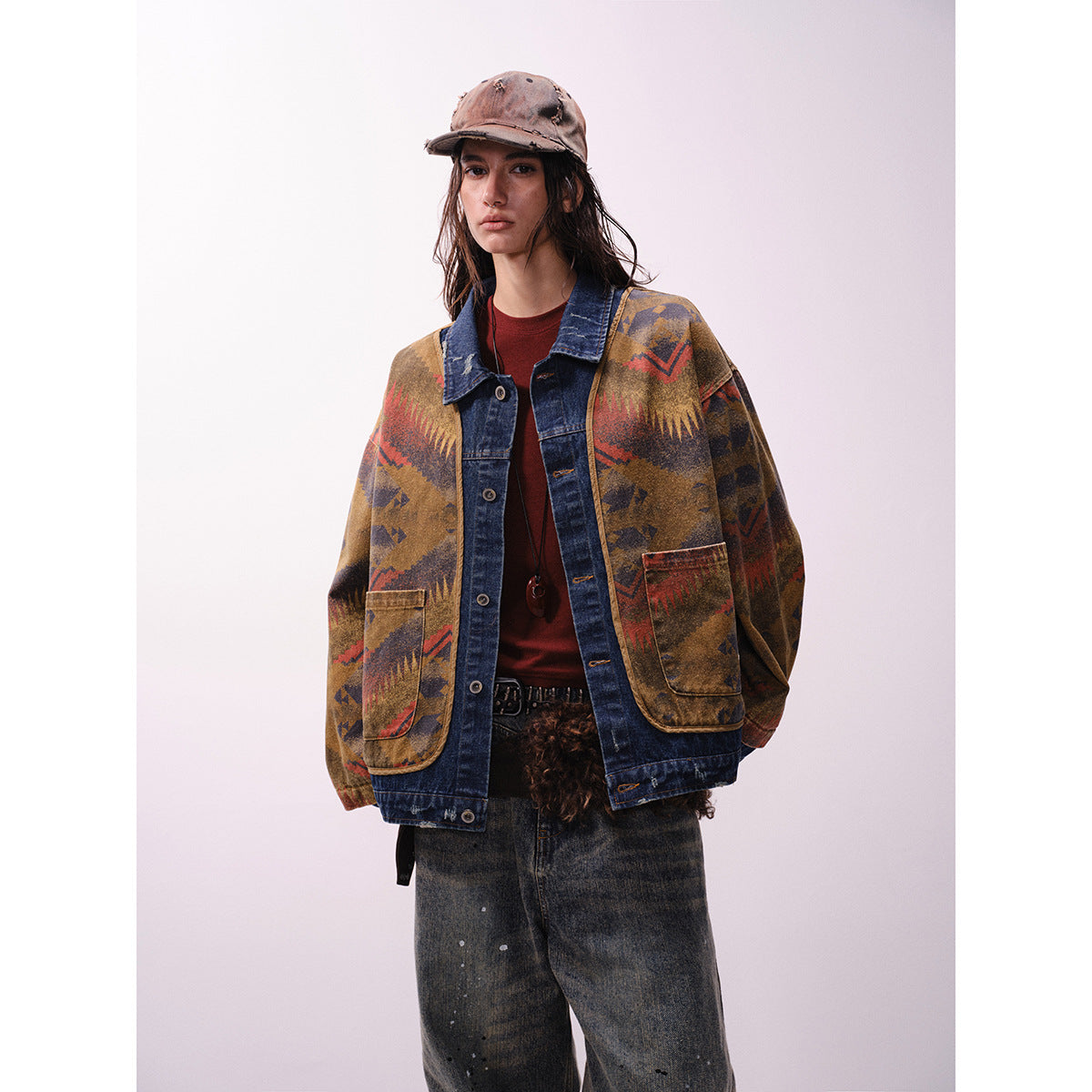 Closer front view of a model in a brown geometric-pattern jacket with dark denim collar, placket and trim.