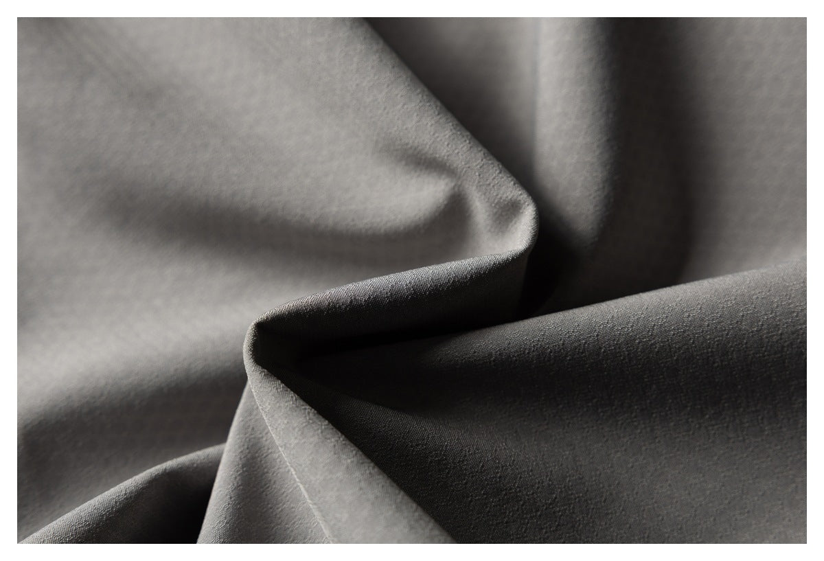 Close-up of softly folded gray garment fabric showing its fine surface texture.